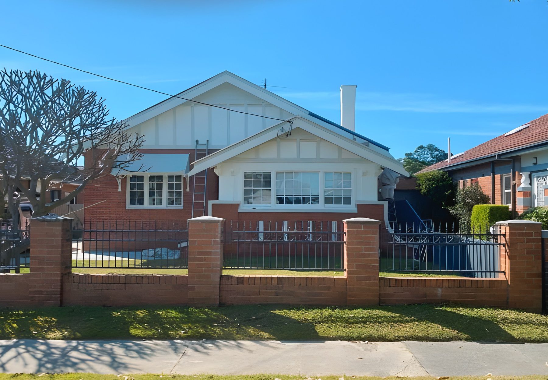 Freshly painted bungalow behind a brick fence