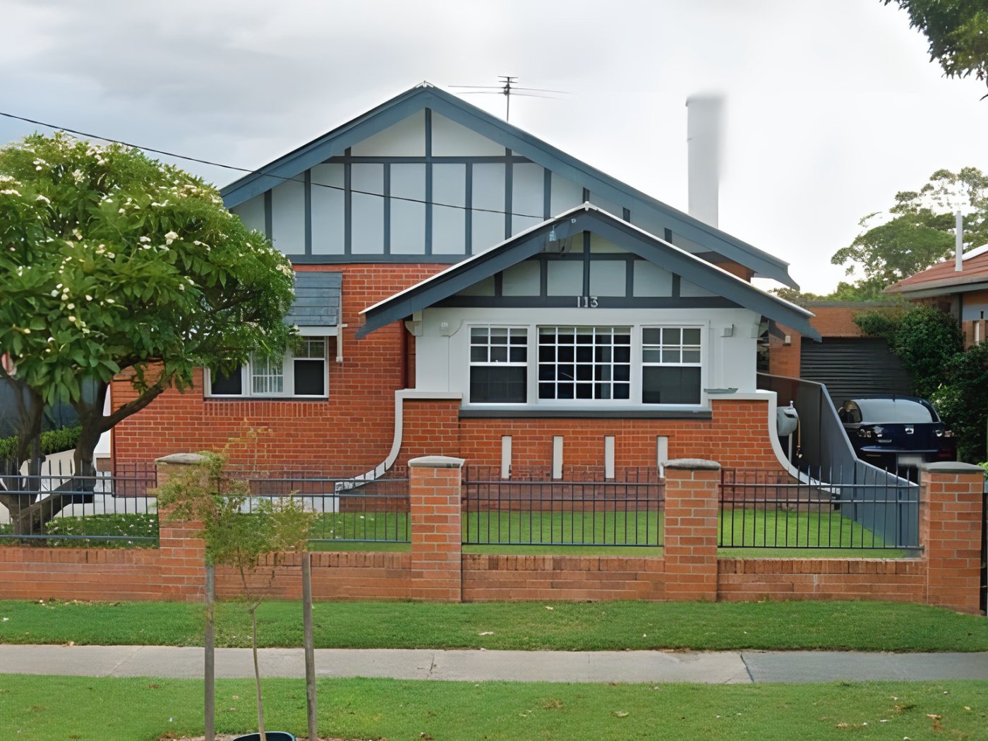 Before: Brick bungalow before painting, with dark grey gable trims