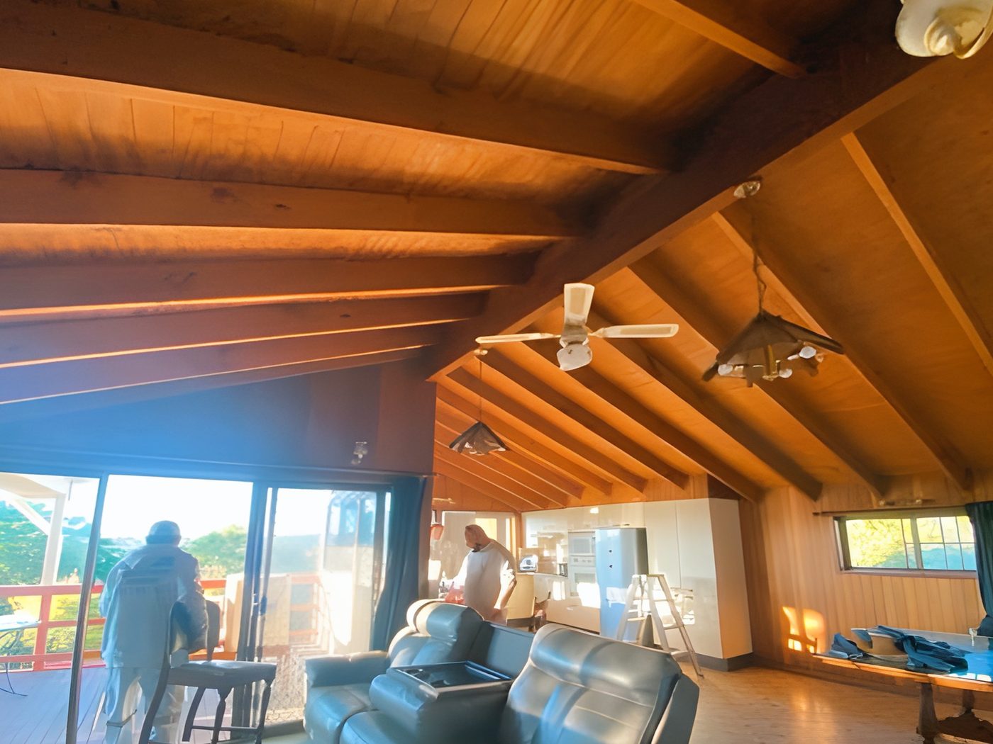 Before: Living room with a stained timber raked ceiling before painting