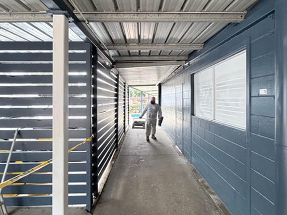 After: The same commercial walkway after its walls, screens and posts were painted