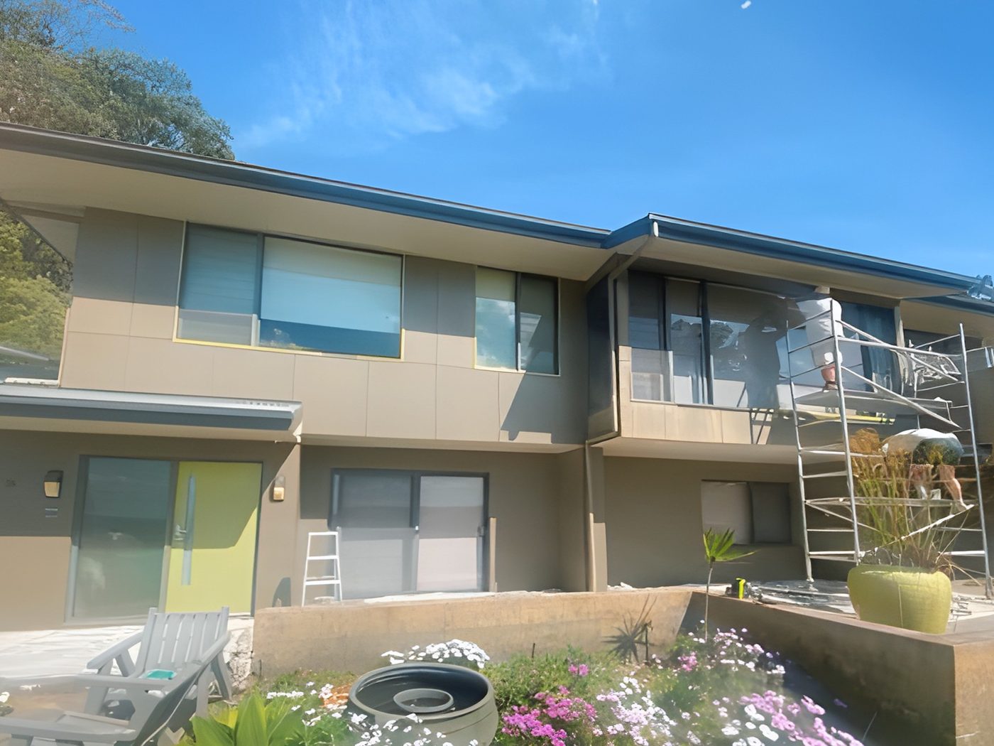 Before: Two storey rendered home during painting, with scaffolding on the upper level