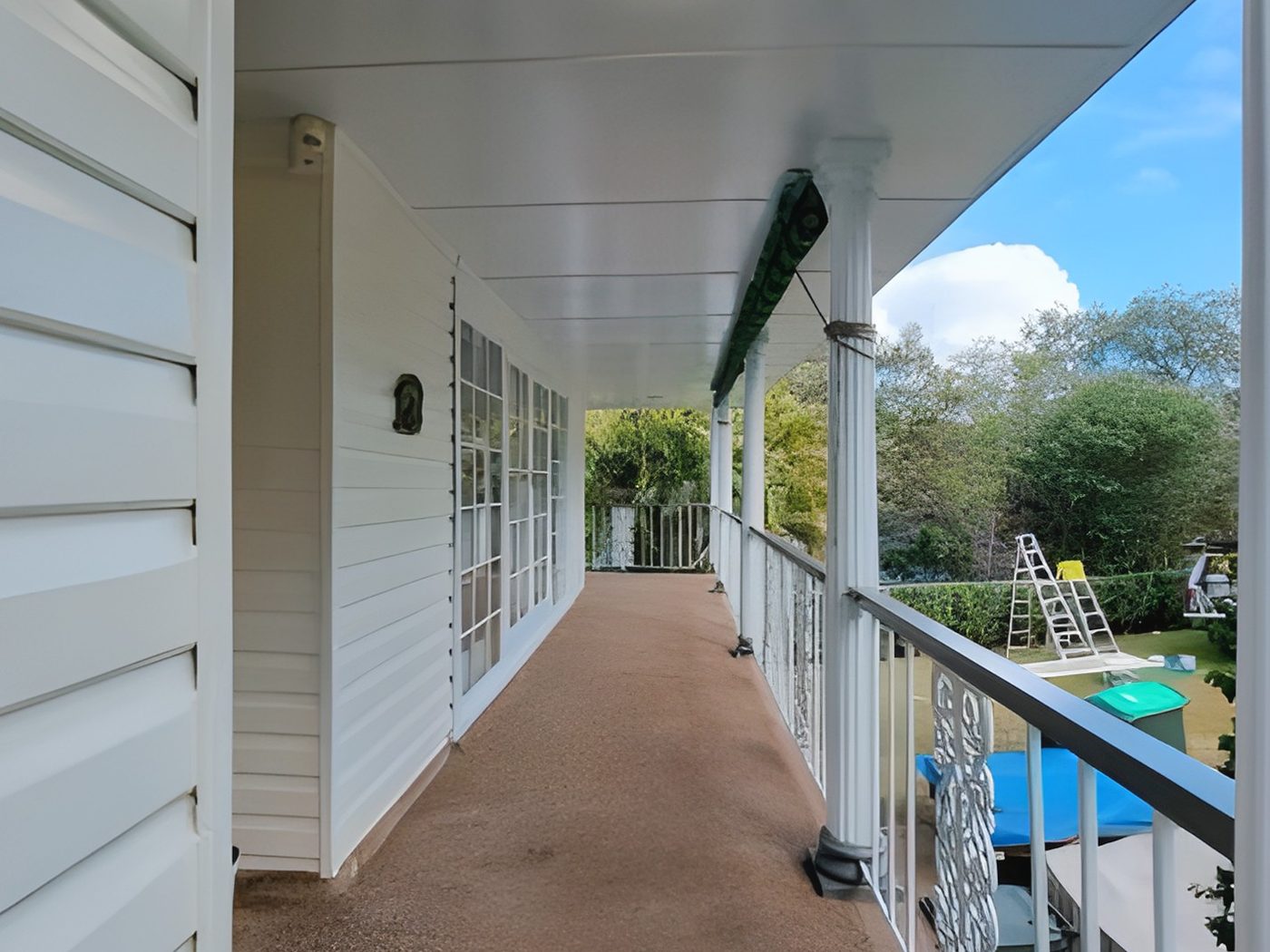 After: The same weatherboard verandah after its walls, ceiling and posts were painted white