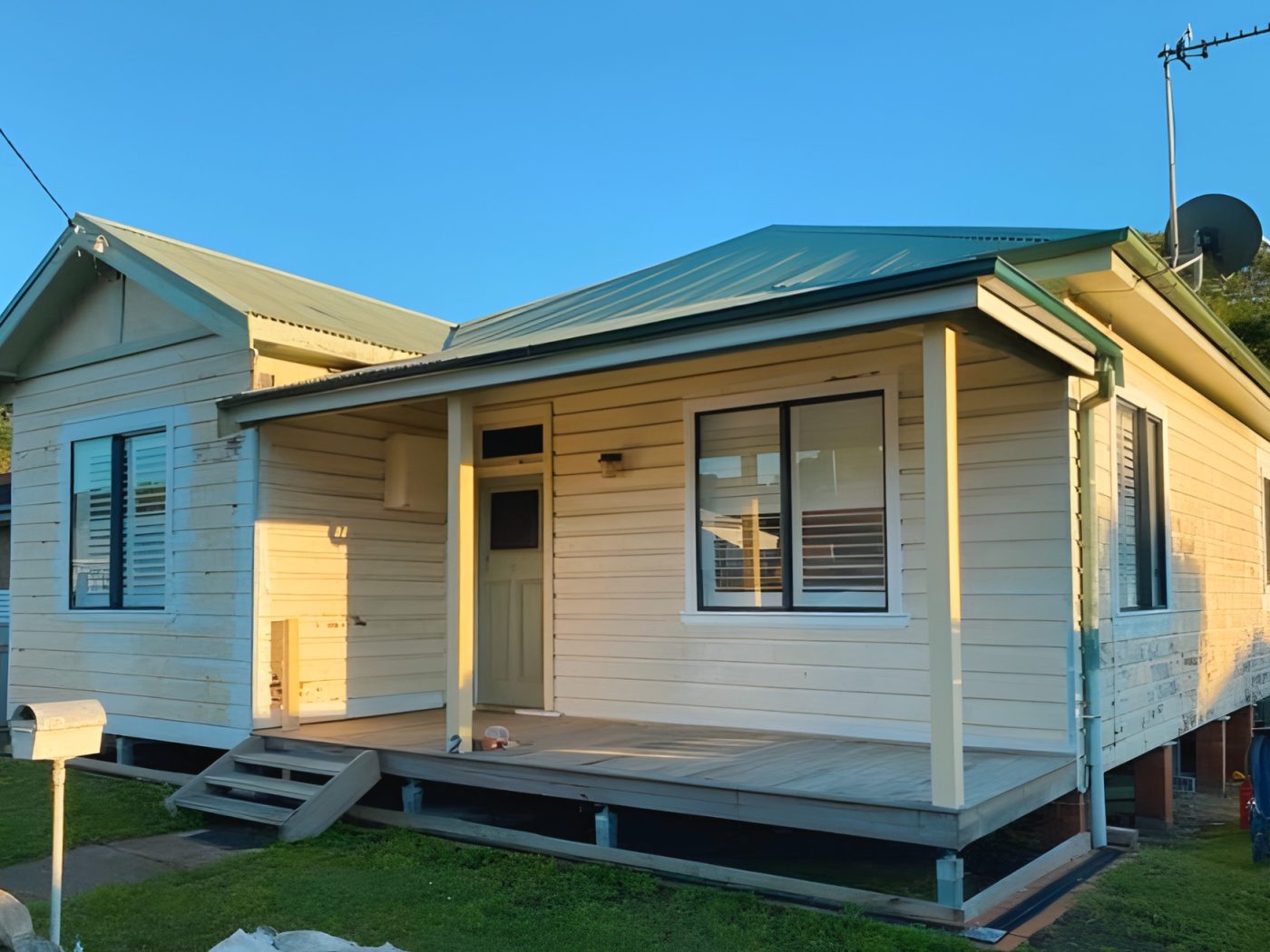 Before: Weatherboard home before painting, with the old cream finish