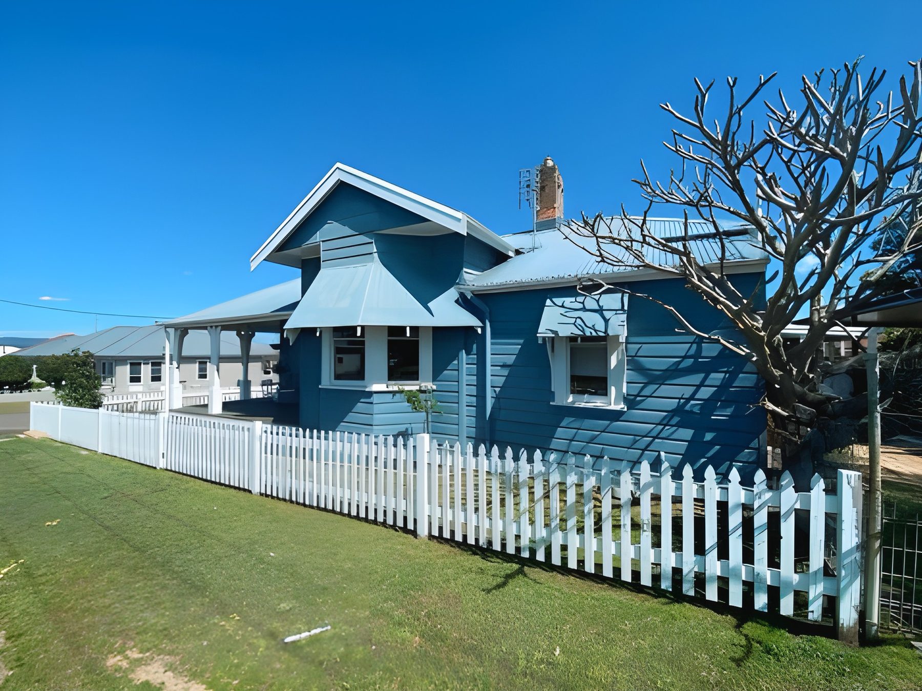 Weatherboard home and picket fence, freshly painted