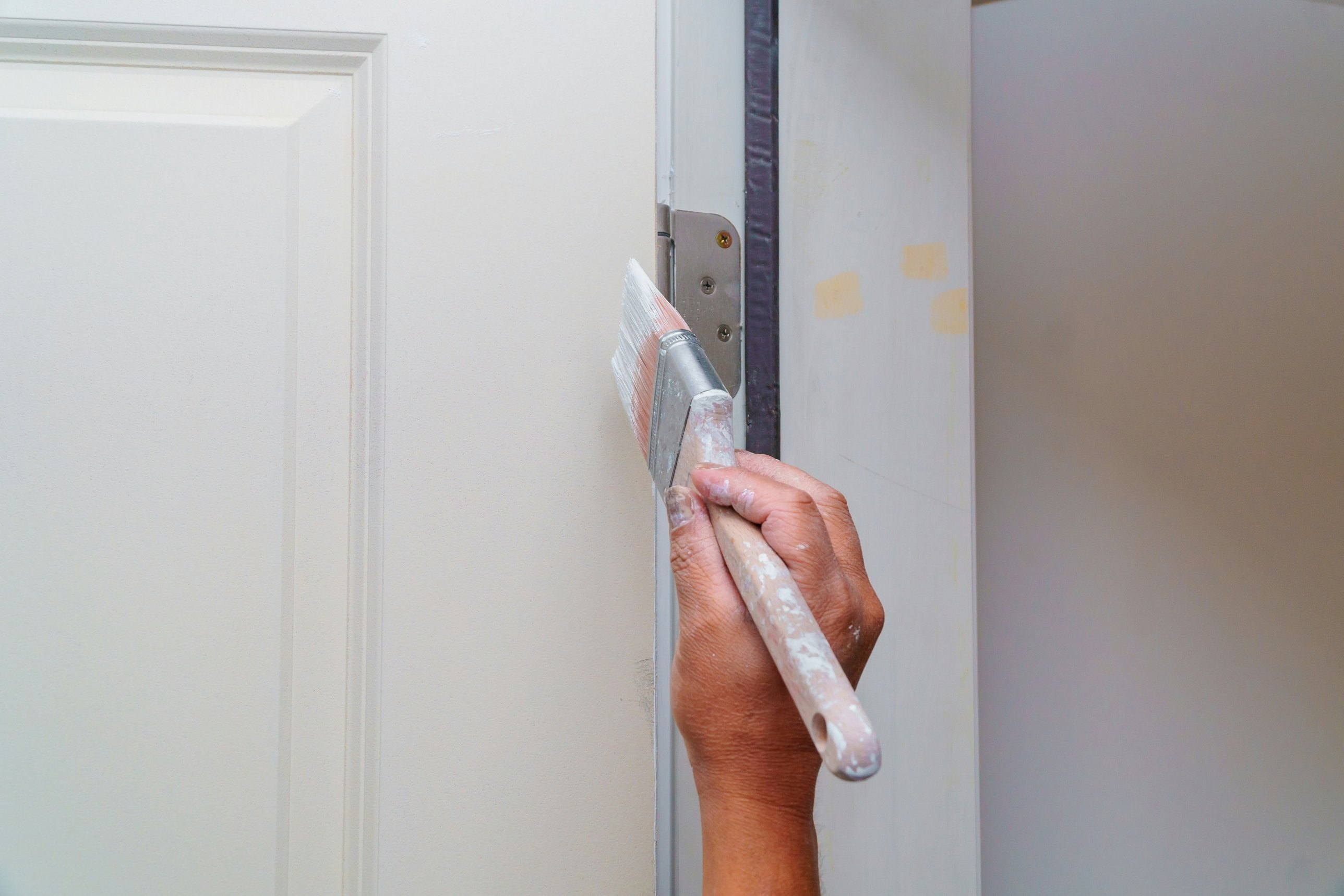 Painter cutting in a white panel door with a brush, Andrew Lindner Painting Newcastle