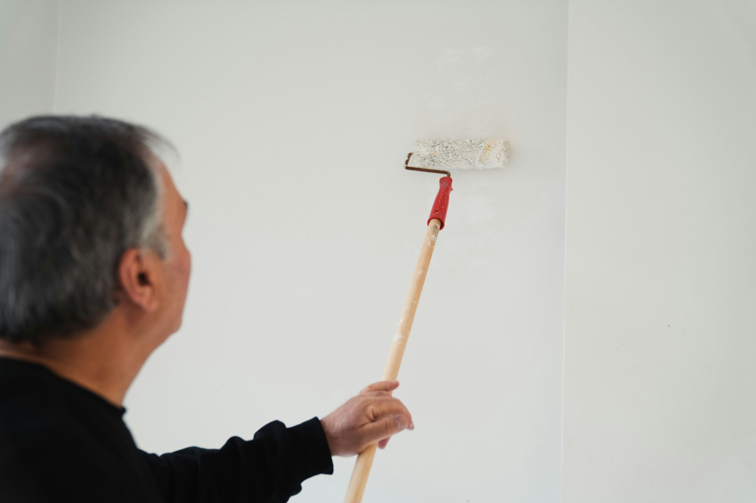 Painter rolling a white interior wall, Andrew Lindner Painting Newcastle